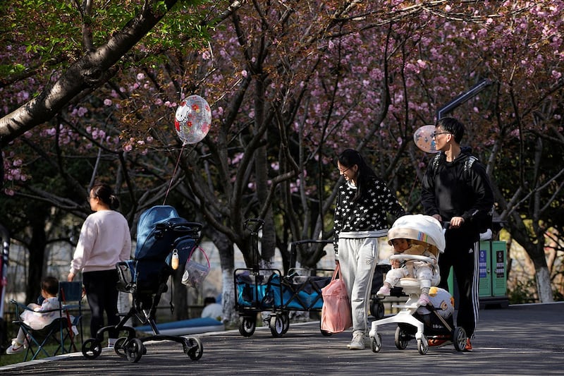 2023年4月2日，在上海公园里，一对父母推着婴儿车。（路透社）